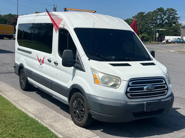 White TCB Escorts escort van with an amber light bar, red warning flags and company decal